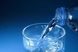 studio shot Clean drinking water poured into glass and natural blue background. healthy drinking water concept photo