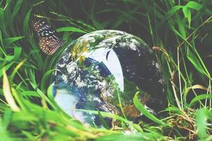 la bola de cristal con el mundo sobre la hierba. concepto del mundo y la naturaleza foto