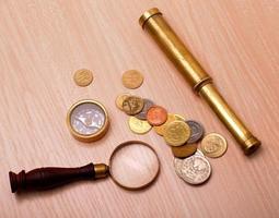 compass, telescope, magnifier and coin photo