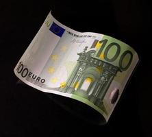 billete de cien euros detrás de la ola foto