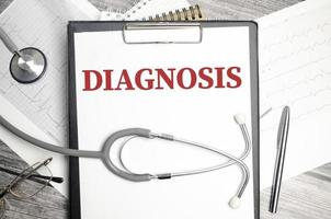 Diagnosis word on white notepad and stethoscope photo