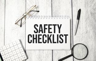 Safety Checklist. folder with a calculator on a white sheet of paper on a wooden background. photo