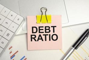 Office desk table with paper sheet, notepad ,chart and calculator. Top view text debt ratio photo