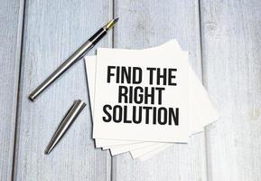 Find The Right Solution text, written on a sticker with pen on wooden background photo
