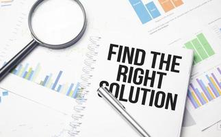 Find The Right Solution text on white notebook and pen on wooden background photo