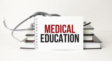 The text MEDICAL EDUCATION on a notebook on a white table next to a stethoscope photo