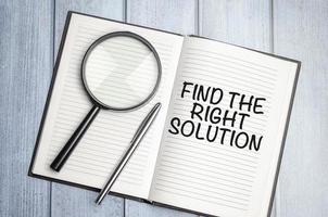 magnifying glass and a white notebook with the text Find The Right Solution photo