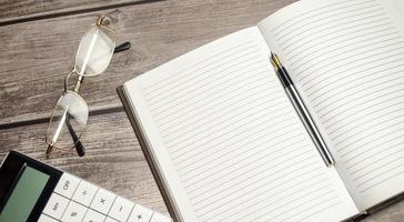 Papers with charts and glass magnifier with pen. Calculator photo