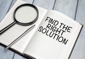 magnifying glass and a white notebook with the text Find The Right Solution photo