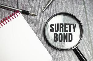 a magnifying glass with the inscription - Surety Bond photo