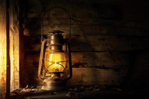 Antique lantern kerosene on an old overgrown wood photo