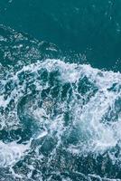 Beautiful sea waves with foam of blue and turquoise color. Abstract blue sea water with white wave. Blue and white waves of the ship road on the water sea ocean. photo