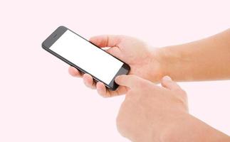 mano hol teléfono negro aislado sobre fondo de color rosa, pantalla en blanco foto