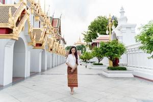 Asia woman wearing traditional dress of Thailand walking meditation around temple of Ratchanatdaram bangkok photo