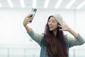 asian woman use 5g smart phone to live stream in the mall photo