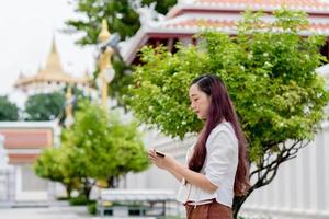 mujer budista asiática con traje tradicional de tailandia leyendo sánscrito antiguo libro tripitaka del señor buddha dhamma foto