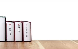 Books with words DEI, diversity, equity, inclusion on wood table with white background. photo