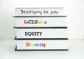 Books with words DEI, diversity, equity, inclusion on table with white background. photo