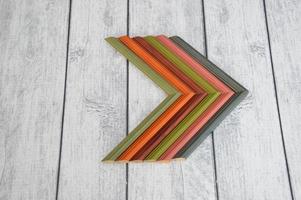 esquinas de marco de madera de colores modernos sobre un fondo gris de madera. baguettes de muestra de color cuidadosamente dobladas foto