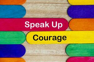 Speak up and courage text on color wooden stick - Courage and business concept photo
