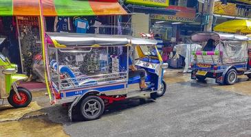 Ratchatchewi Bangkok Thailand 2018 Typical colorful tuk tuks taxis driving people in Bangkok Thailand. photo