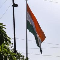 India flag flying high at Connaught Place with pride in blue sky, India flag fluttering, Indian Flag on Independence Day and Republic Day of India, tilt up shot, waving Indian flag, Flying India flags photo