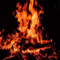 llamas de fuego sobre fondo negro, fondo de textura de llama de fuego blaze, maravillosamente, el fuego está ardiendo, llamas de fuego con madera y hoguera de estiércol de vaca foto