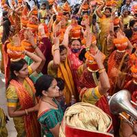 New Delhi, India April 03 2022 - Women with Kalash on head during Jagannath Temple Mangal Kalash Yatra, Indian Hindu devotees carry earthen pots containing sacred water with a coconut on top photo