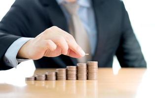 Close-up Of A Businessman Making Stack Of Coins photo