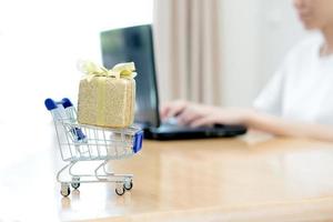 Hand holding Laptop with small shopping cart photo