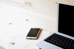 laptop and smart phone on a wooden table. photo