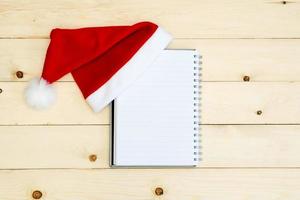 Santa hat and diary  on wooden table photo