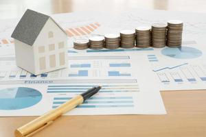 With House Model And Stack Of Coins On Desk photo