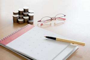 Pen and coins on calendar photo