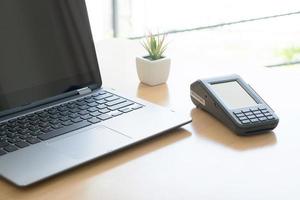 Payment terminal with contactless credit card and laptop, finance concept photo