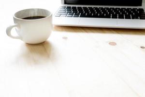 Office table with laptop computer and coffee cup photo