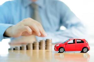 Businessman a toy car and a stack of coins photo