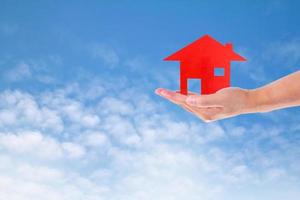 Man Holding House  on sky photo