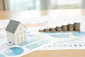 With House Model And Stack Of Coins On Desk photo