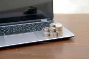 Stack coins on laptop. Financial, photo