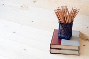 lápices y libros. sobre fondo de madera. foto