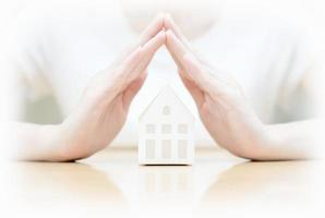 Female hands saving Miniature House photo