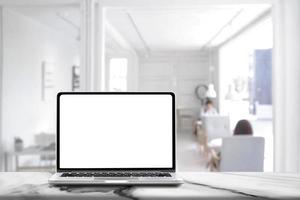 Laptop computer with blank white screen on marble table with modern workplace background , Social distancing Concept photo