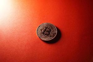 moneda criptográfica bitcoin aislada sobre fondo rojo. foto