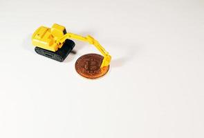 figura excavadora parada frente a bitcoin. concepto de minería bitcoin. foto