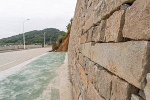 A stone wall and an empty road photo