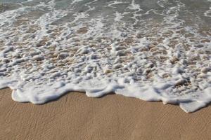 smooth waves on the beautiful brown sand photo