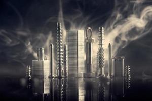Abstract panorama of city illuminated by bright light with reflection, made by metal bolt, staples for paper stapler and nut chrome. Black background with bokeh and smoke . photo