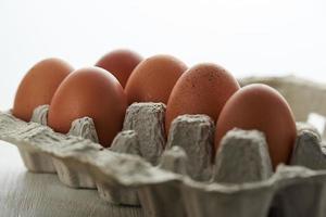 Eggs in a protective container on white background. Foreground and background in blur. photo