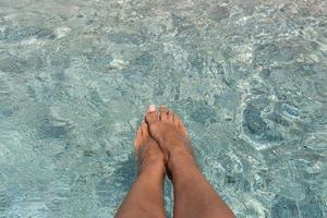 feet in the water on the beach